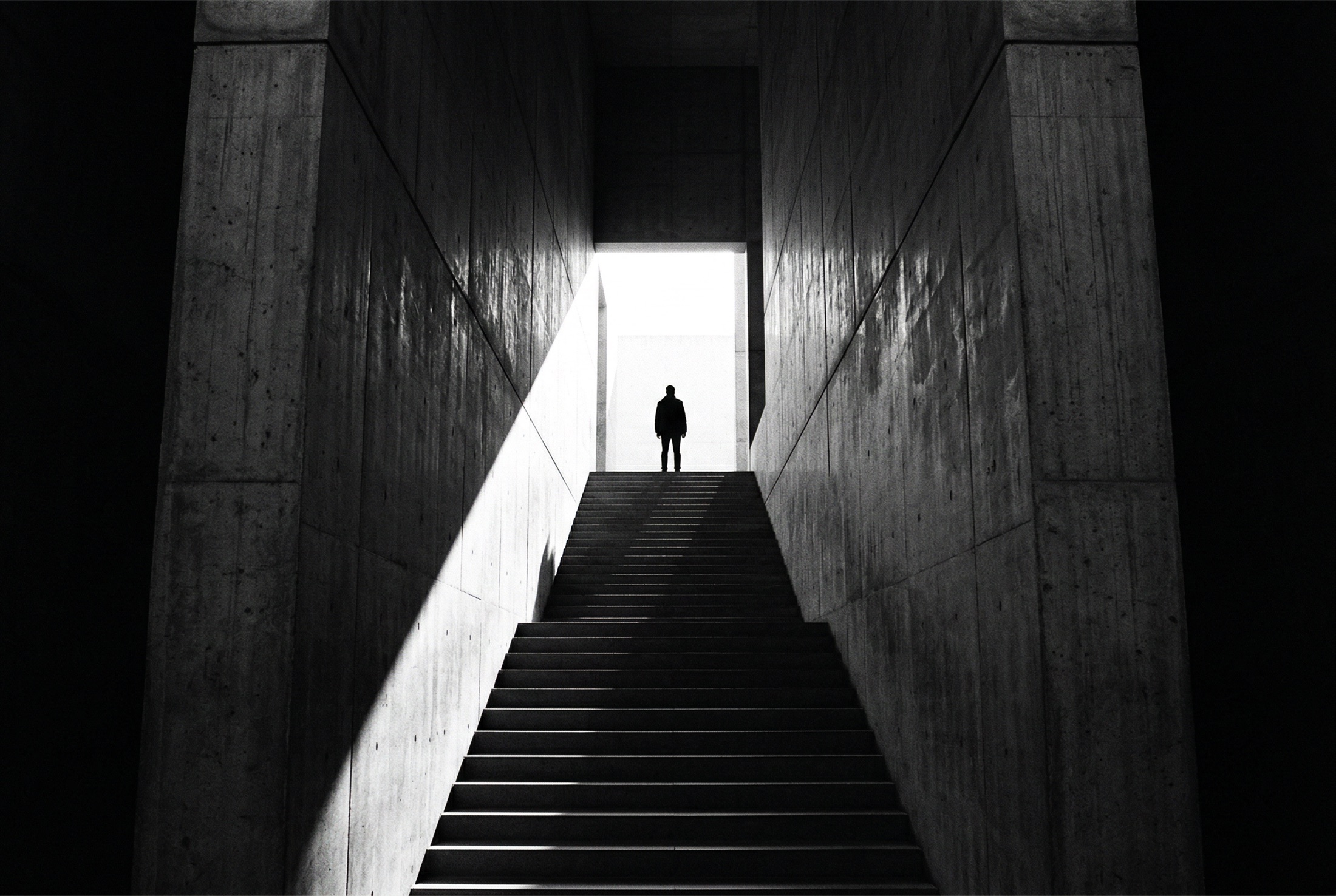 Figura atravessando uma arquitetura de concreto e luz